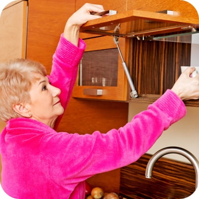Elderly woman reaching up to shelf